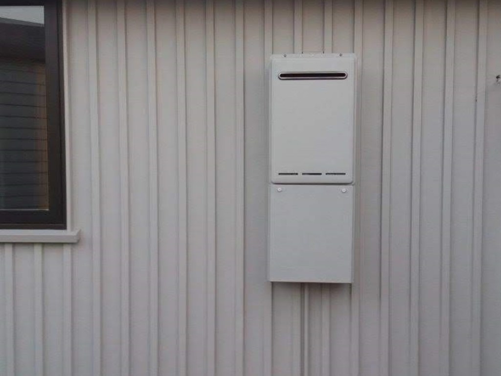 Photo showing Infinity hot water system cabinet affixed to outside wall of residence, colour matched to exterior finish